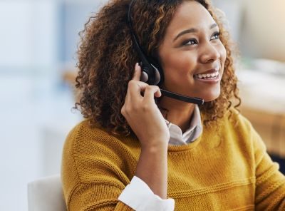 Afbeelding van een doktersassistente die aan de telefoon zit voor haar computerscherm