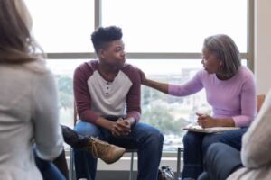 Afbeelding van een zorgprofessional die in gesprek is met een jongere